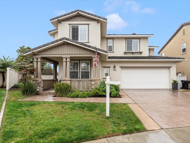 view of front of property featuring a garage, a front yard, and a porch