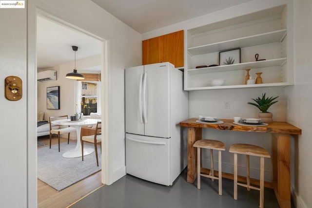 kitchen with pendant lighting, a wall mounted AC, and white fridge