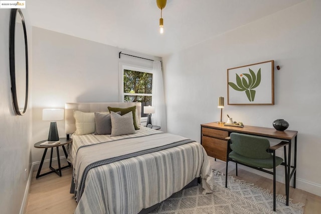 bedroom featuring fridge and light hardwood / wood-style floors