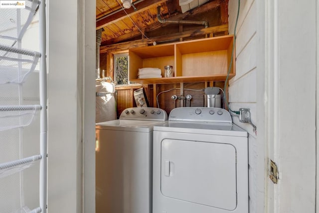 clothes washing area with washer and clothes dryer and wooden ceiling