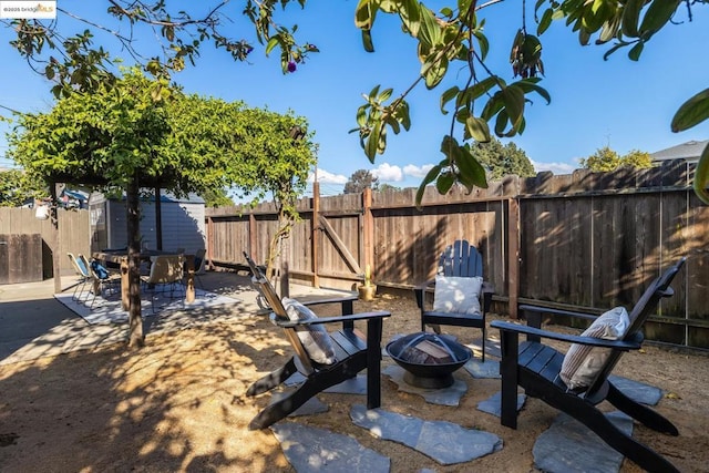 view of yard featuring a storage shed, a patio, and an outdoor fire pit