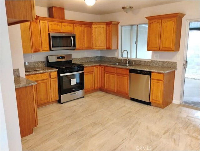 kitchen featuring sink, stainless steel appliances, and dark stone counters