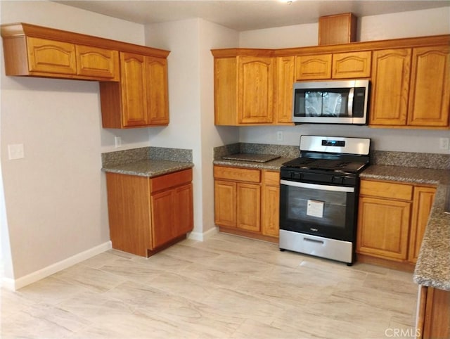 kitchen featuring appliances with stainless steel finishes and dark stone countertops