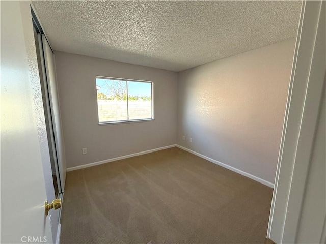 unfurnished room featuring a textured ceiling and carpet flooring