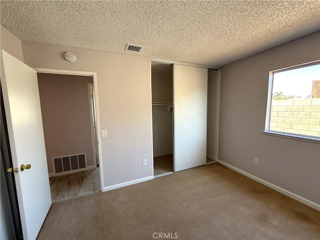 unfurnished bedroom featuring carpet floors, a closet, and a textured ceiling