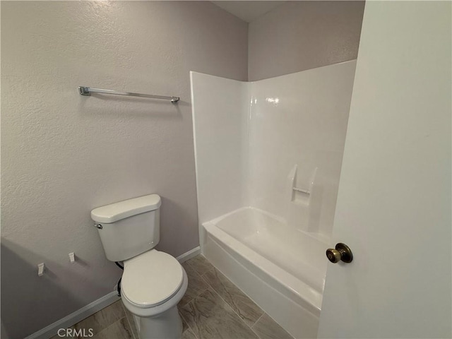 bathroom with washtub / shower combination and toilet