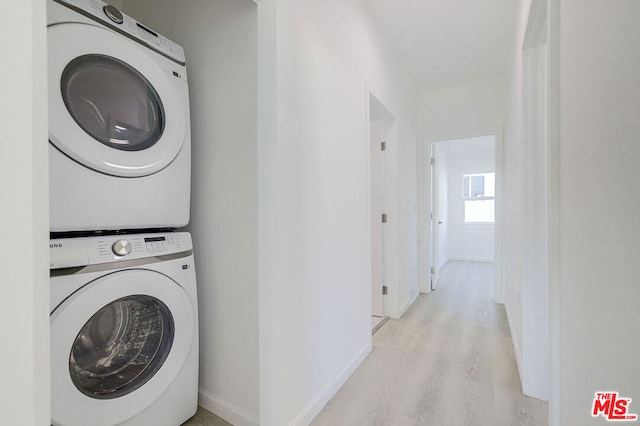 washroom featuring stacked washer and clothes dryer and light wood-type flooring