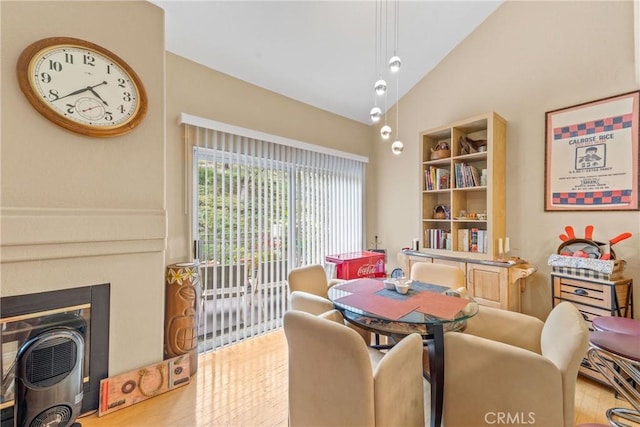 dining room with lofted ceiling and light wood-type flooring