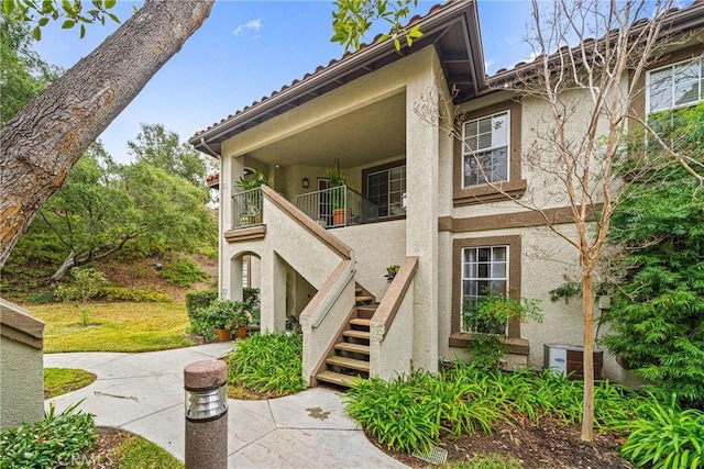 view of front of property with central AC and a balcony