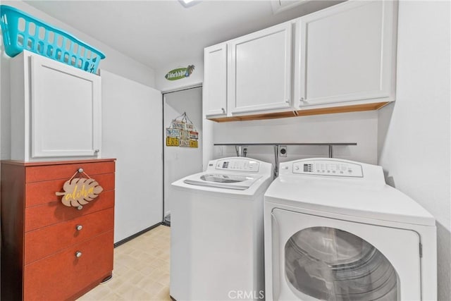 laundry room featuring cabinets and washer and clothes dryer