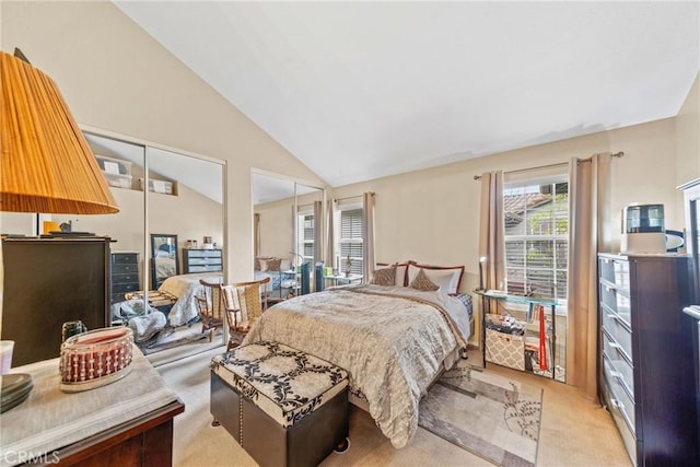 bedroom with multiple closets, vaulted ceiling, and light carpet