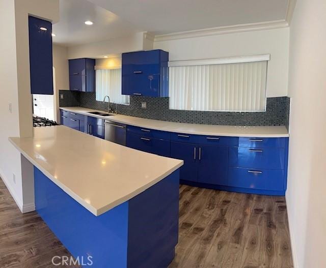 kitchen featuring blue cabinets, sink, a kitchen breakfast bar, kitchen peninsula, and dark wood-type flooring