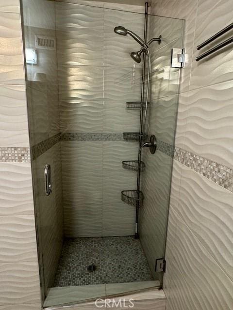 bathroom with a shower with door