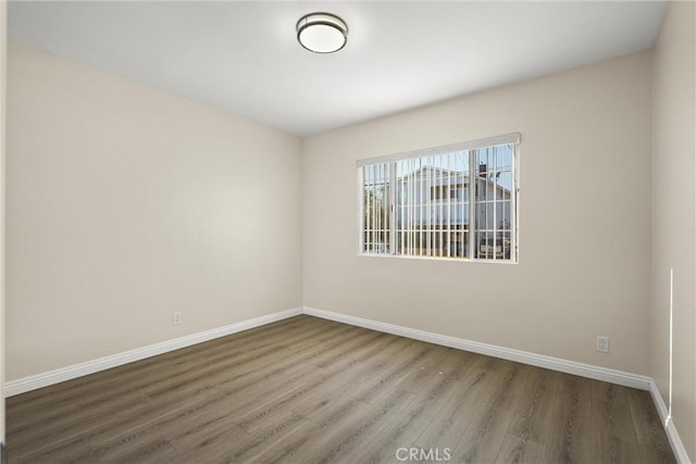 empty room featuring baseboards and wood finished floors