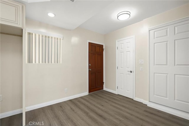 interior space featuring baseboards, dark wood-type flooring, and recessed lighting