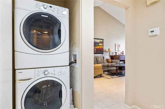 washroom featuring stacked washing maching and dryer and light tile patterned floors