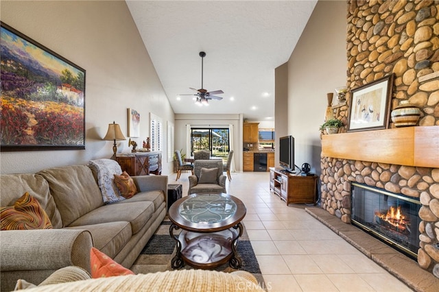 tiled living room featuring ceiling fan, a fireplace, and high vaulted ceiling