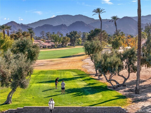 view of property's community with a mountain view and a lawn