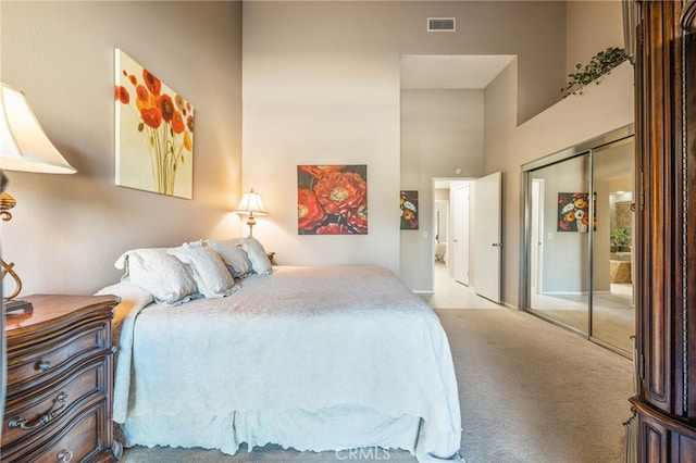 bedroom with a high ceiling, light carpet, and a closet