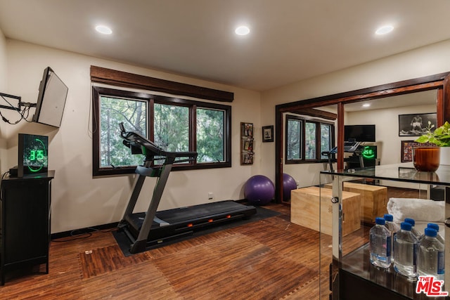 exercise room with dark wood-type flooring