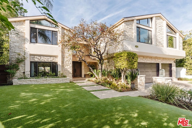 view of front of property featuring a garage and a front yard