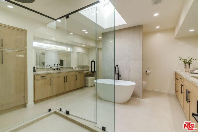 bathroom with vanity, a skylight, tile patterned floors, and plus walk in shower