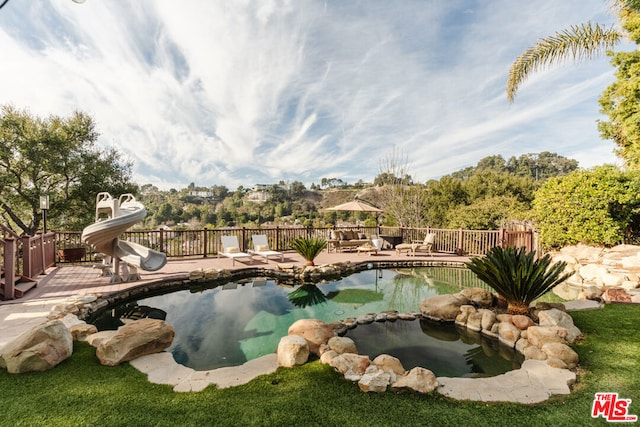 view of swimming pool featuring a water slide and a patio area