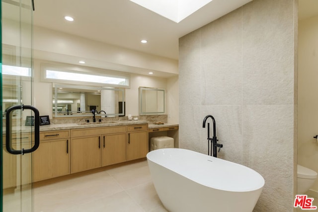 bathroom with vanity, a bath, and tile patterned flooring