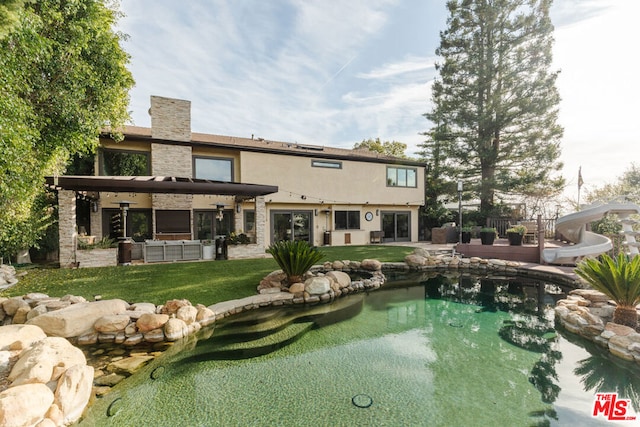 rear view of house with a lawn and a patio