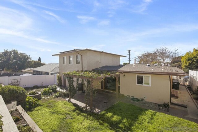 rear view of property featuring a patio and a yard