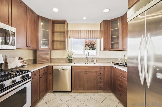 kitchen featuring stainless steel appliances, sink, and light tile patterned floors