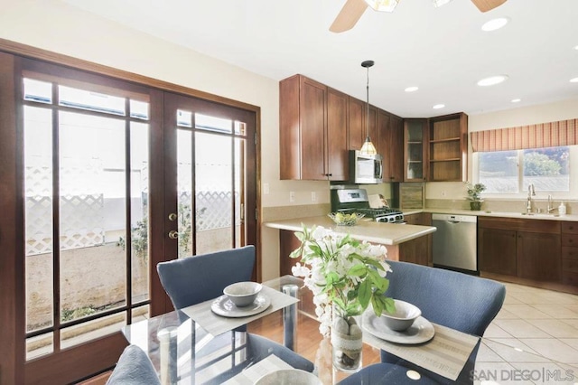 kitchen featuring french doors, sink, hanging light fixtures, light tile patterned floors, and stainless steel appliances