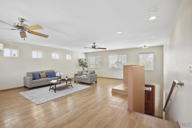 living room with a wall mounted air conditioner and light wood-type flooring