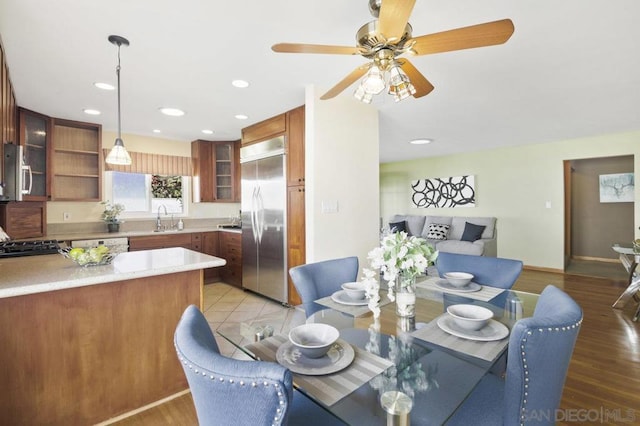 dining area featuring sink, light hardwood / wood-style flooring, and ceiling fan