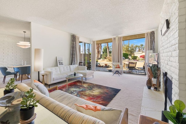 carpeted living room with a fireplace, expansive windows, and a textured ceiling