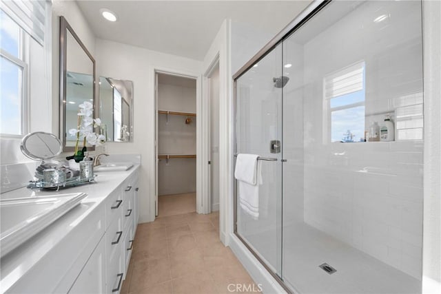 bathroom with tile patterned floors, a shower with shower door, and vanity