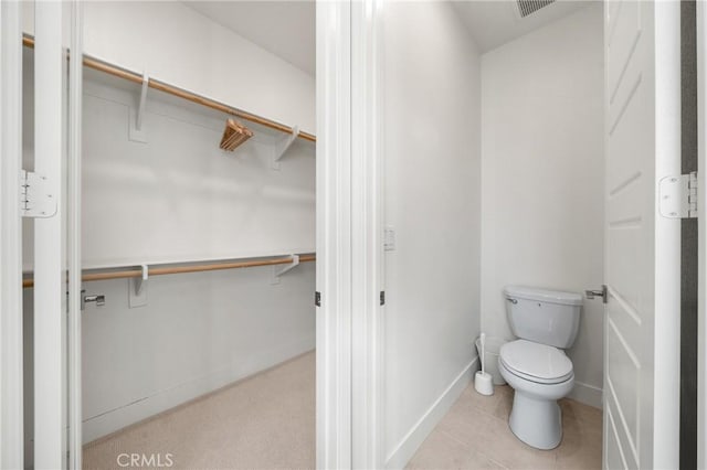 bathroom featuring toilet and tile patterned flooring