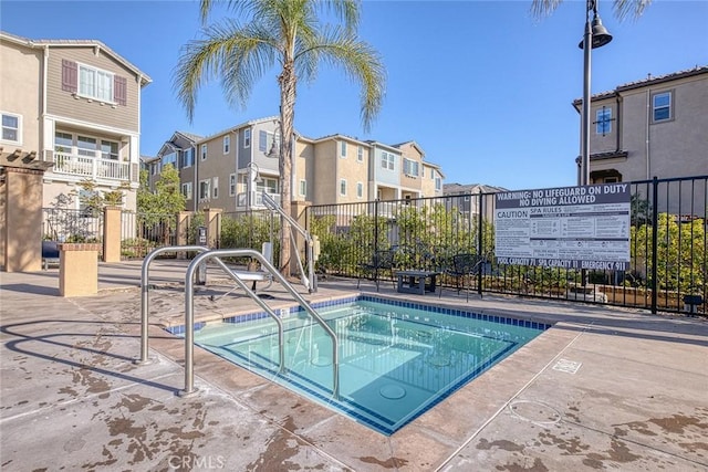 view of swimming pool featuring a hot tub and a patio area