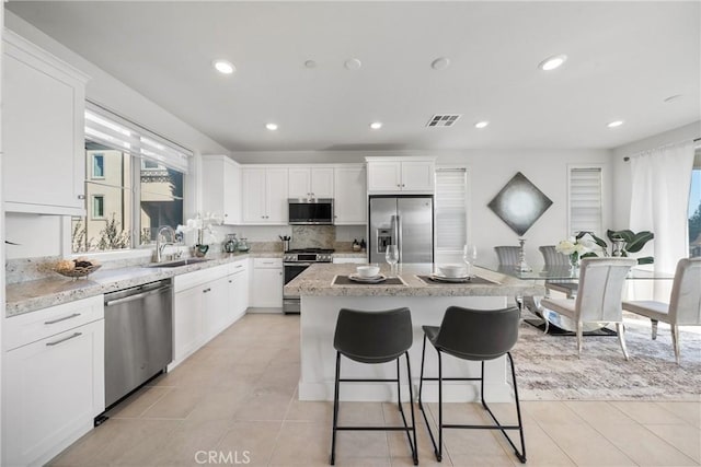 kitchen with stainless steel appliances, a center island, and white cabinets