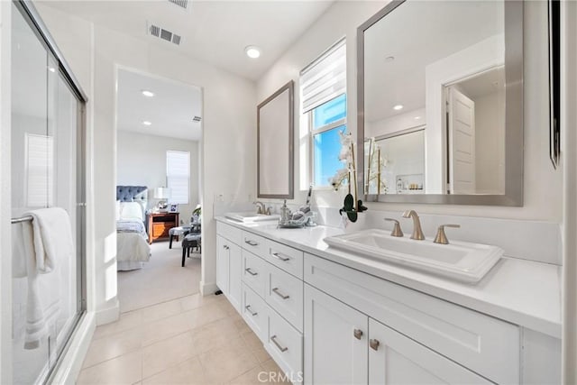 bathroom featuring a shower with door, vanity, and tile patterned floors