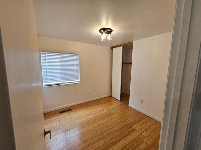 unfurnished bedroom with a closet and light hardwood / wood-style flooring