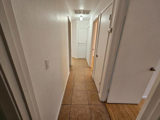 hall with light tile patterned floors