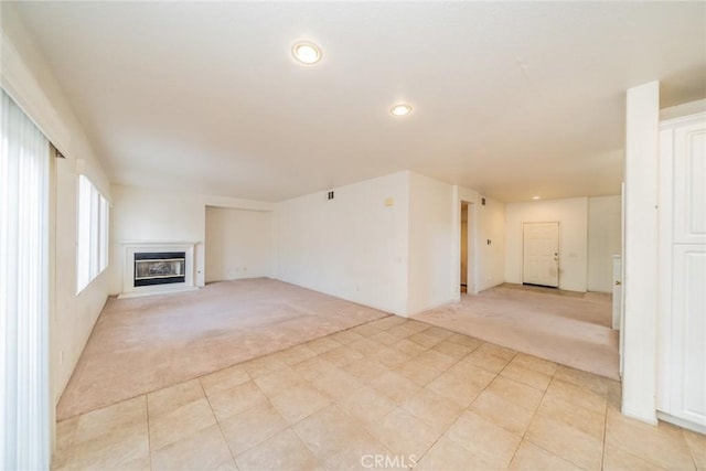 unfurnished living room featuring light carpet