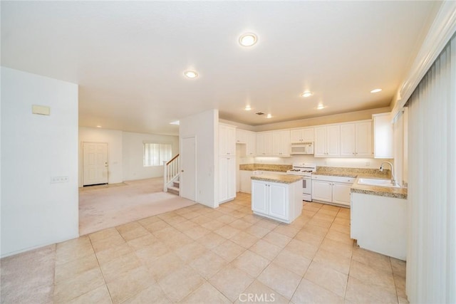 kitchen with sink, white cabinetry, light colored carpet, a kitchen island, and white appliances