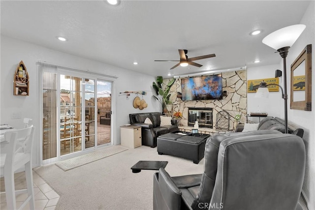 carpeted living room featuring a fireplace and ceiling fan