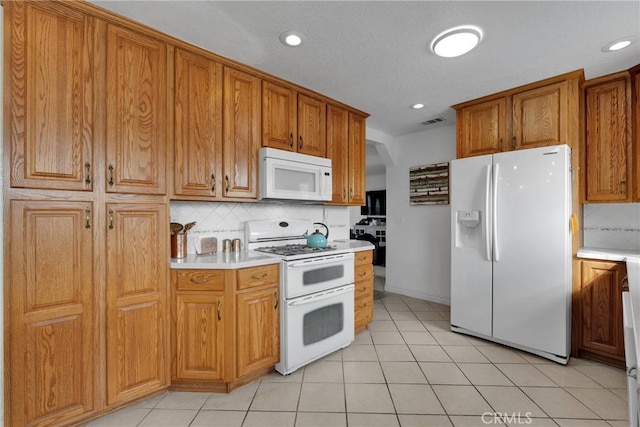 kitchen featuring backsplash, white appliances, and light tile patterned floors