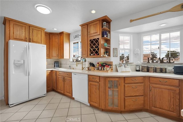 kitchen with tasteful backsplash, white appliances, sink, and light tile patterned floors