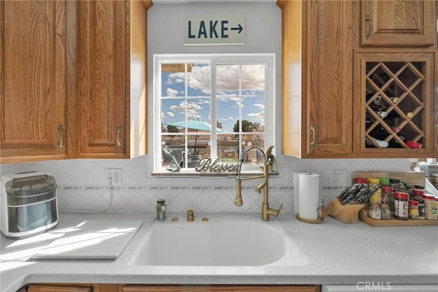 kitchen with dishwashing machine, sink, and decorative backsplash