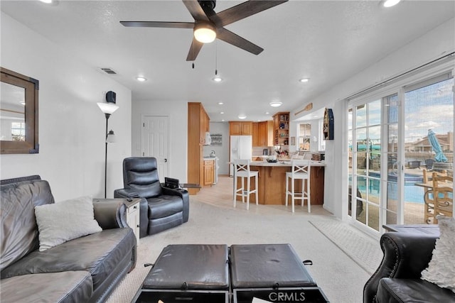 carpeted living room featuring ceiling fan