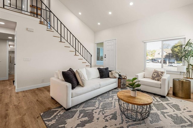 living room with a towering ceiling and hardwood / wood-style floors